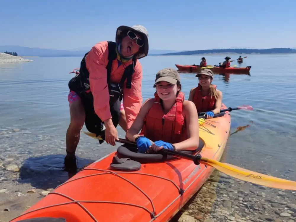 Single person in yellow kayak and white water rapids in Grand Teton National Park.