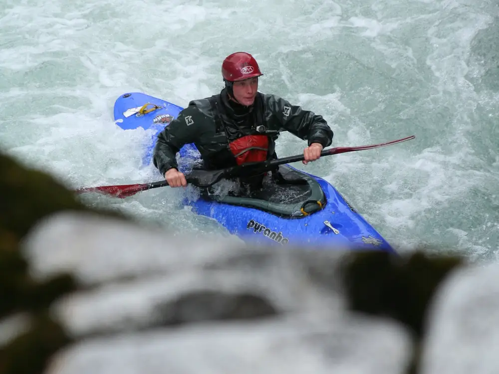 One person in a blue kayak and red helmet on the kayaker in Jackson Hole.