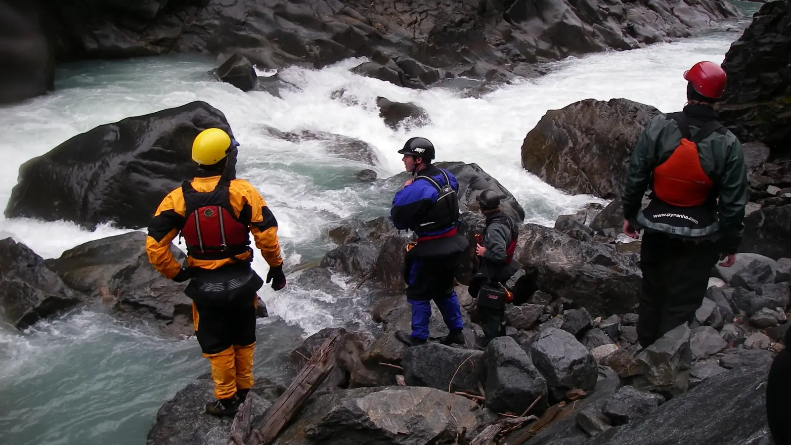 Four people wearing helmets and people wearing life vests in Jackson Hole, Wyoming.