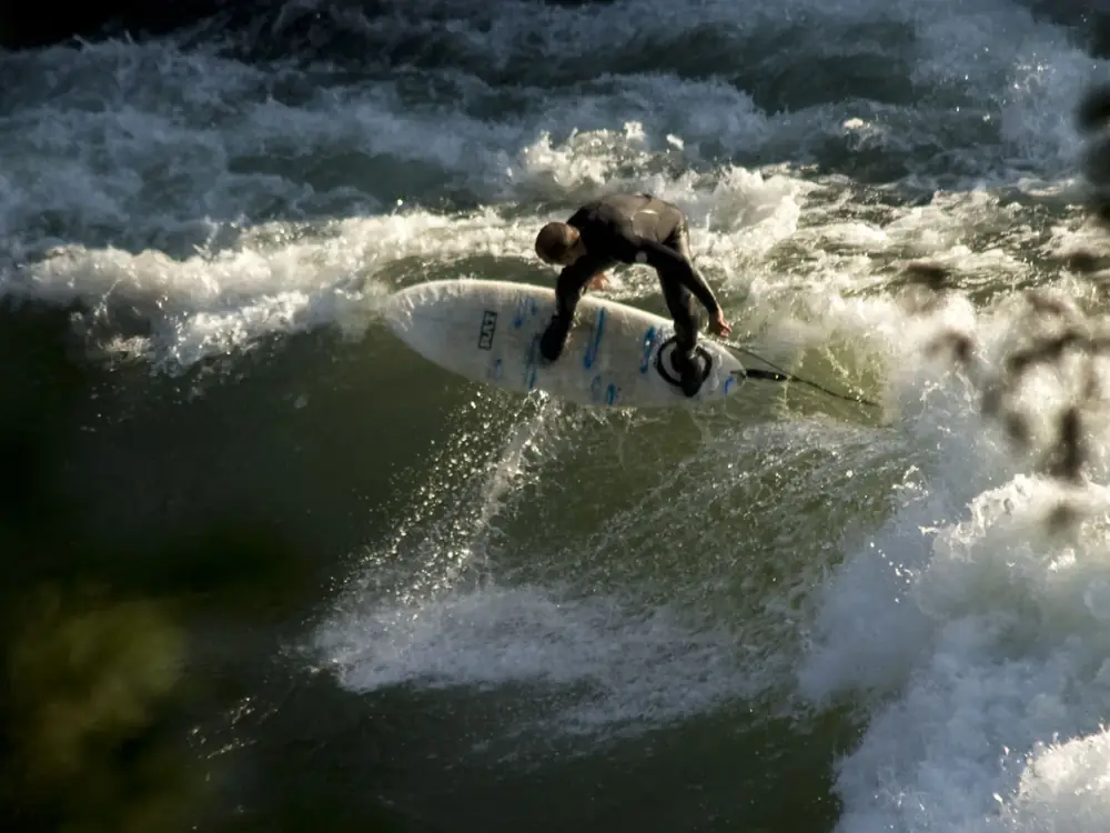 Person in yellow kayak and calm river or lake water in Yellowstone National Park.