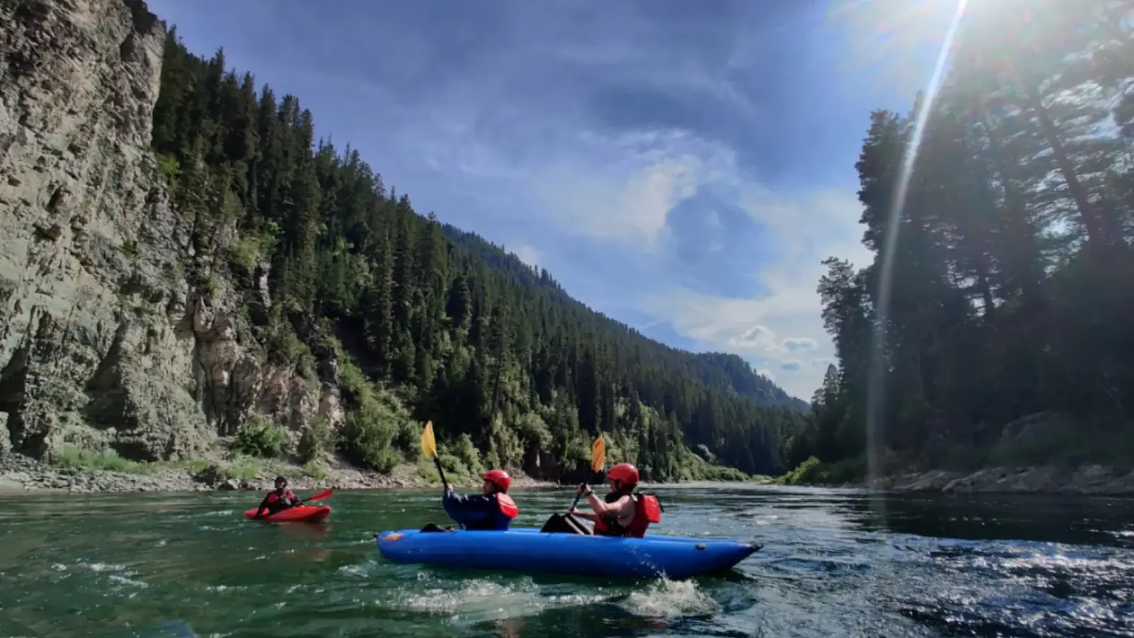 Person in yellow kayak and river with white water rapids in Yellowstone National Park.