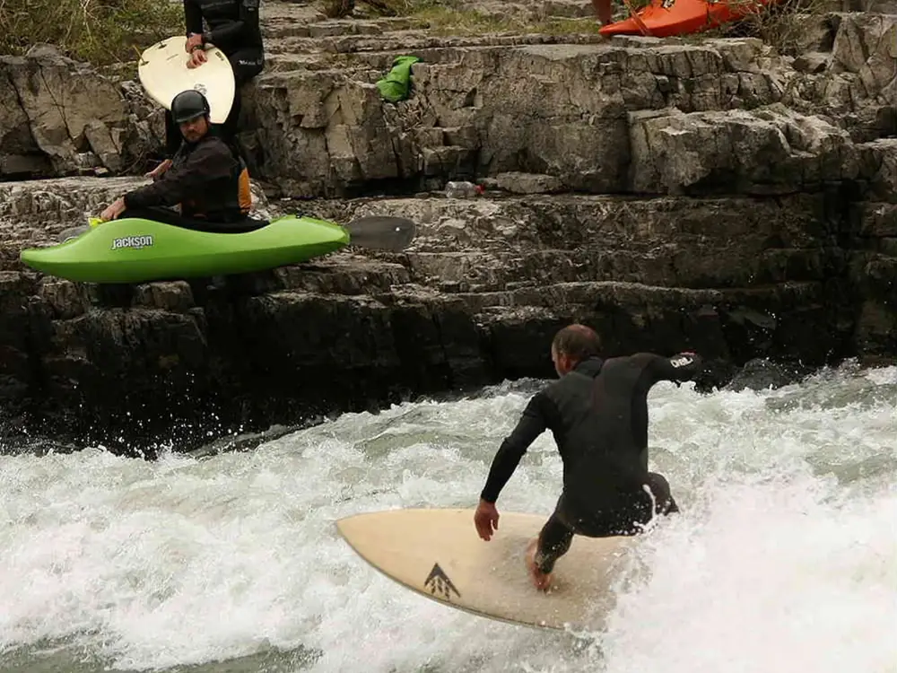 Person in kayak and river with rapids and whitewater in Yellowstone National Park.