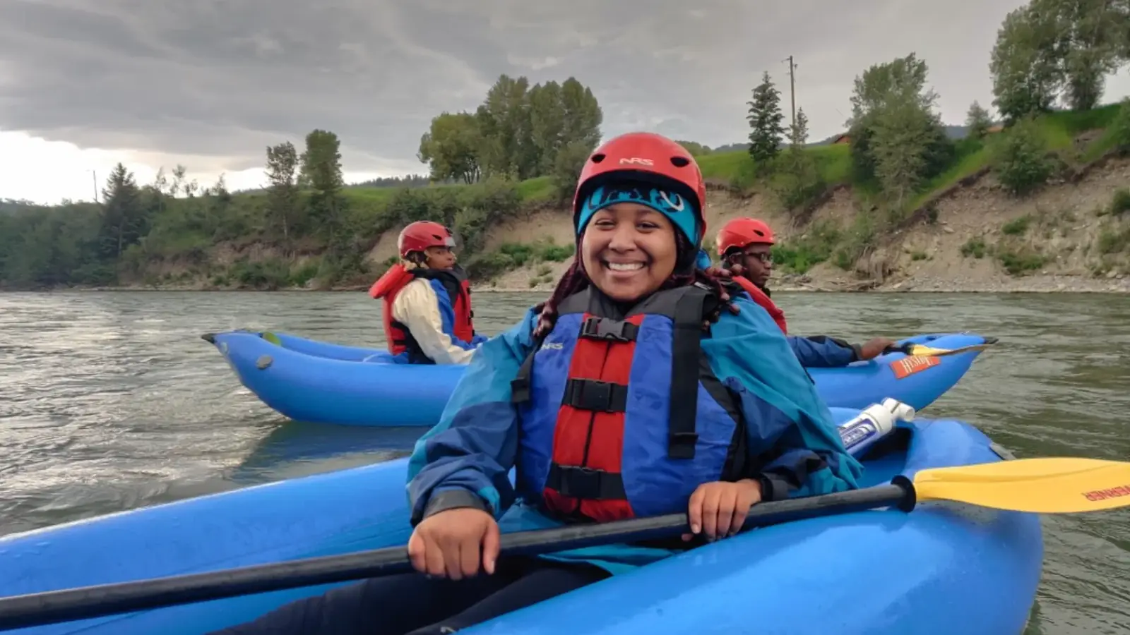 Two people in kayaks and river with rapids and white water in Jackson Hole.