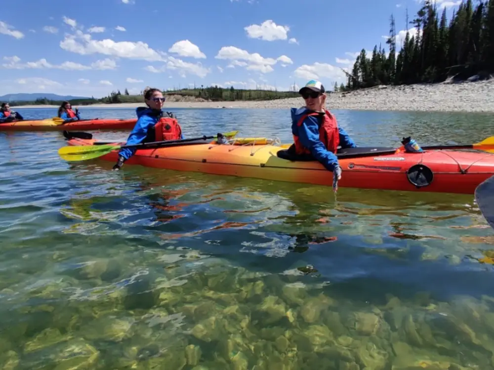 Person in yellow kayak and white water rapids in Grand Teton National Park.