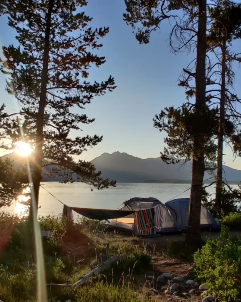 Person in red kayak and river with white water rapids in Jackson Hole.