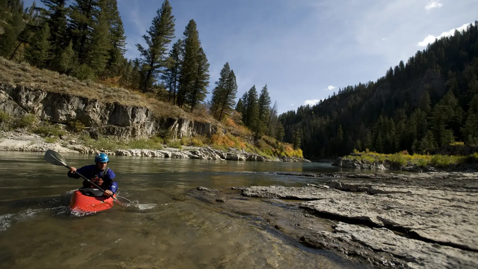 Person in orange kayak and whitewater rapids in Jackson Hole.