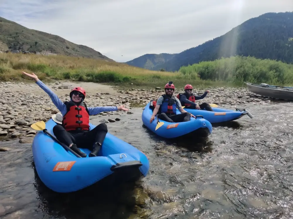 Person in blue kayak and river with whitewater rapids in Jackson Hole.