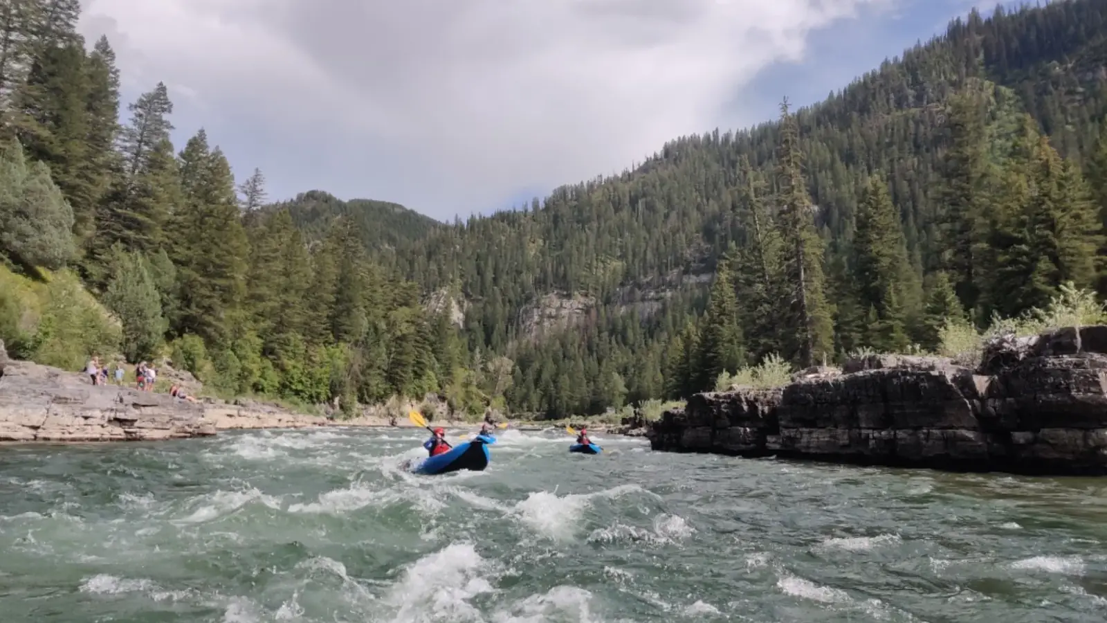 Person in yellow kayak and calm river water in Jackson Hole.