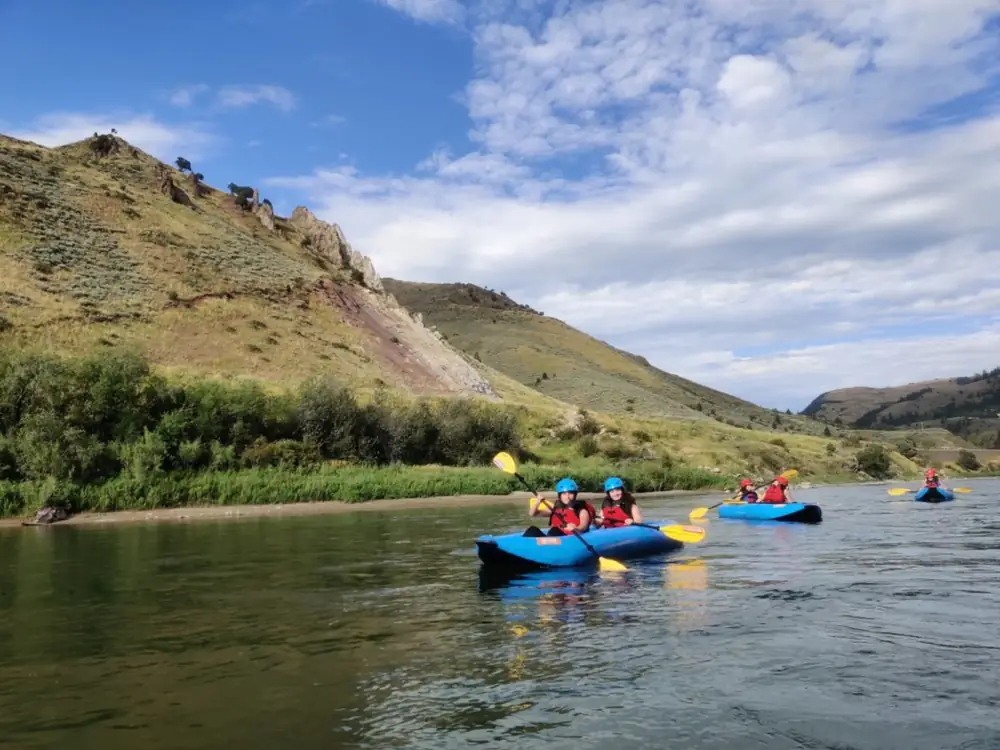 Person in yellow kayak and river with whitewater rapids in Jackson Hole.