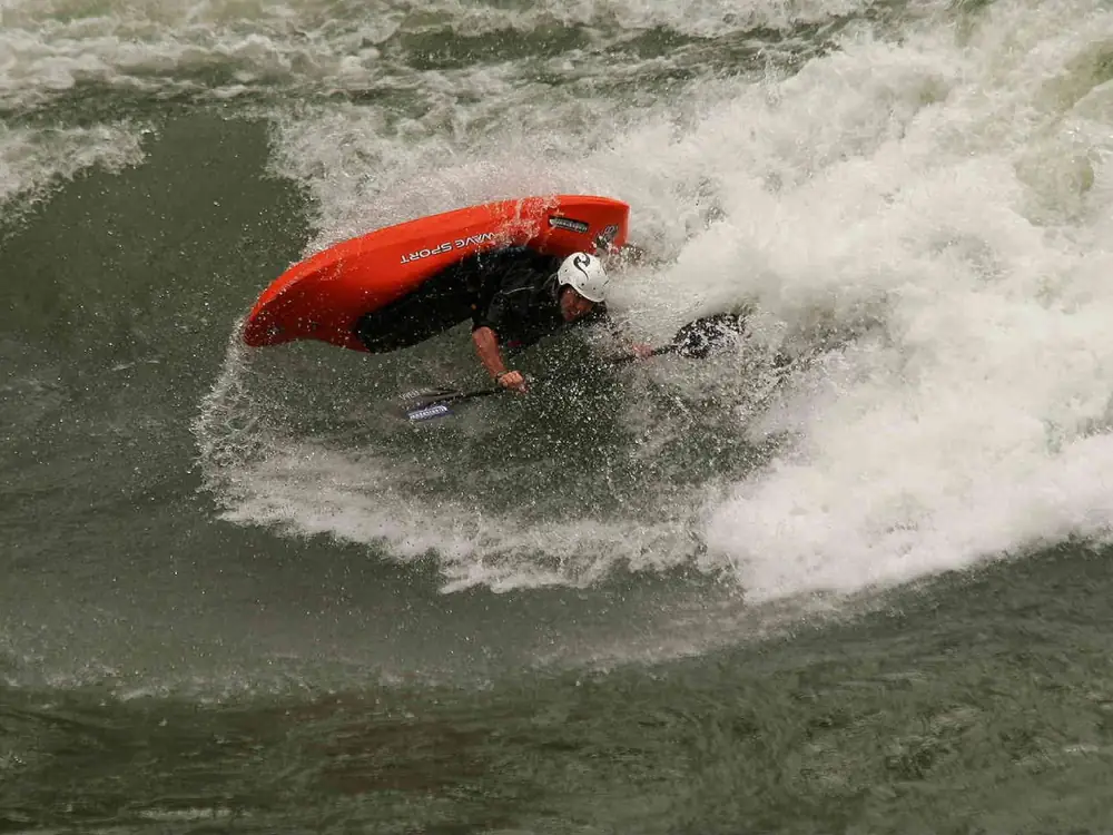 Single person in yellow kayak and calm river water in Jackson Hole.