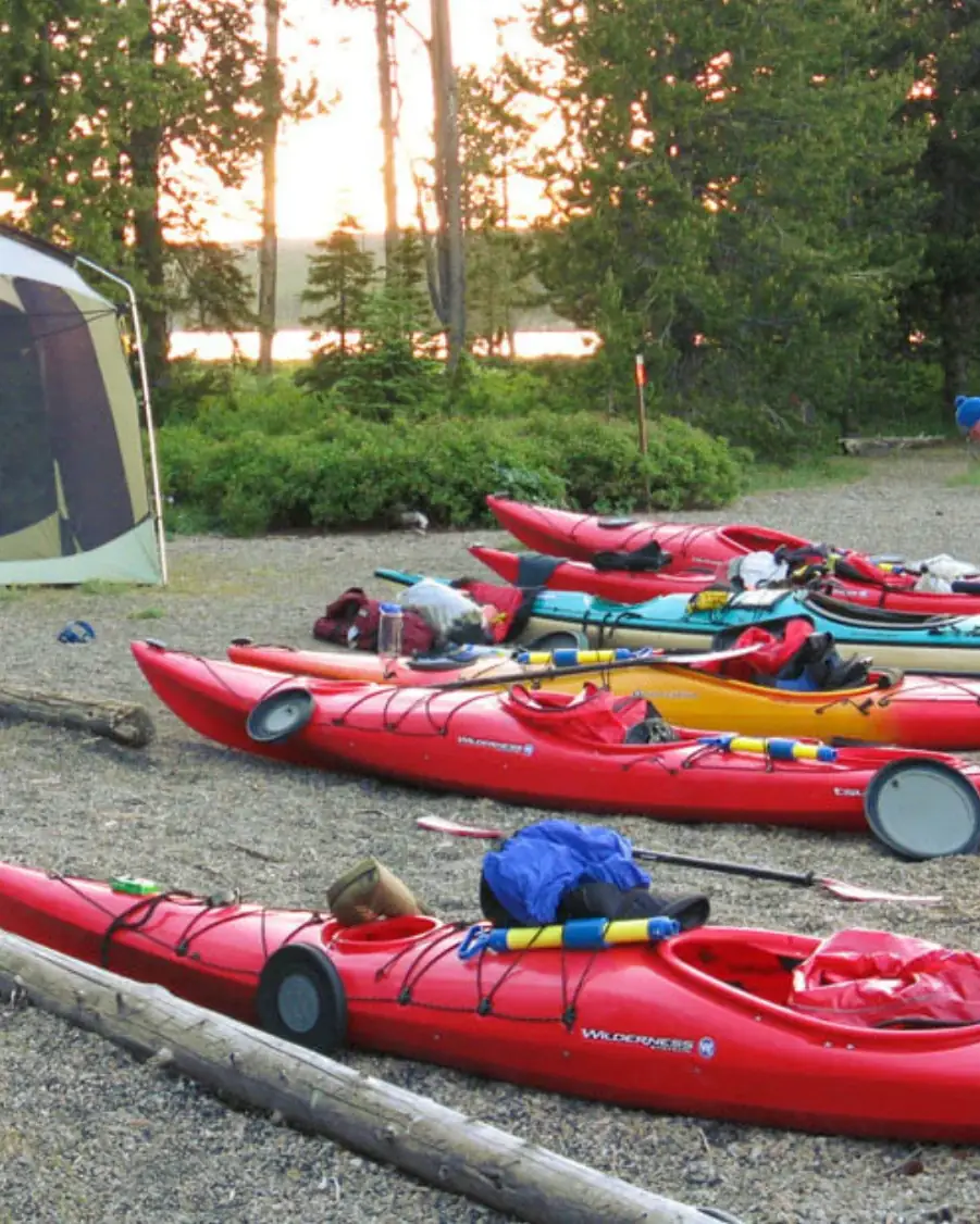 Person in yellow kayak on river and person in red kayak in background in Yellowstone National Park.
