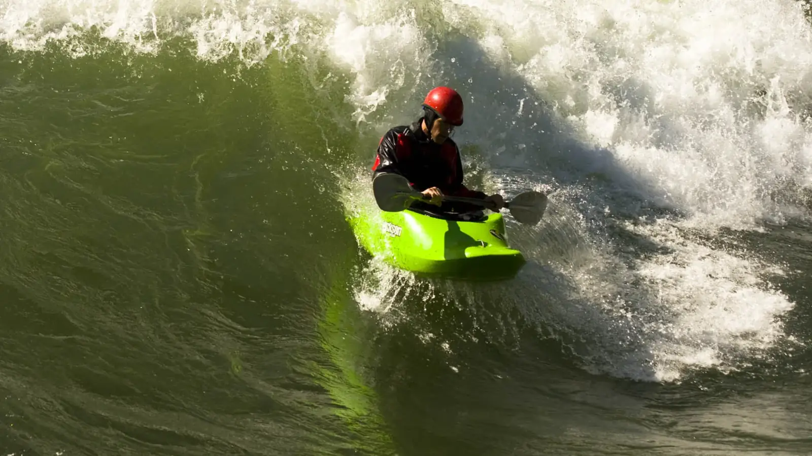 Single person in red kayak and calm river or lake water in Jackson Hole.