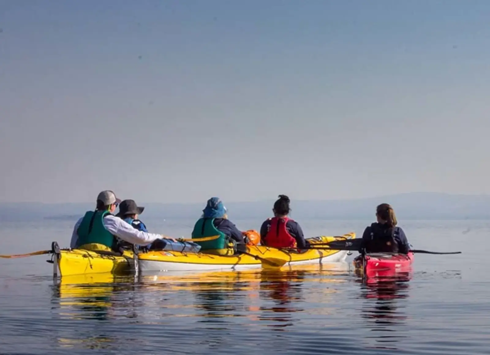 Paddlers on a calm Yellowstone backcountry lake at sunset
