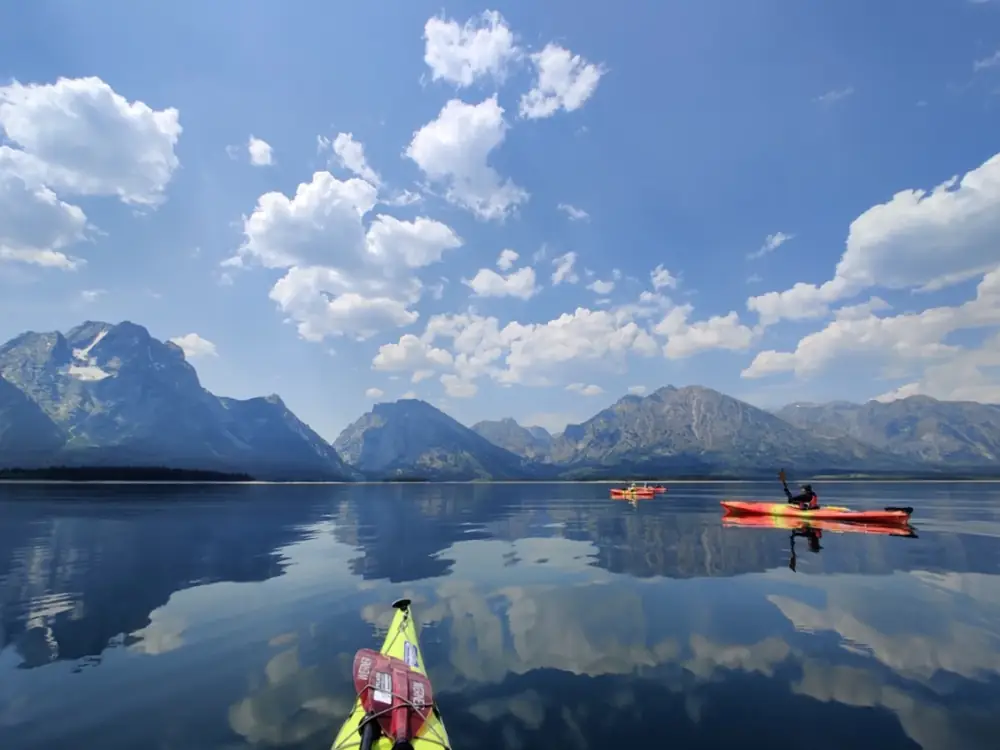 Person in yellow kayak and person in blue kayak in Yellowstone National Park.