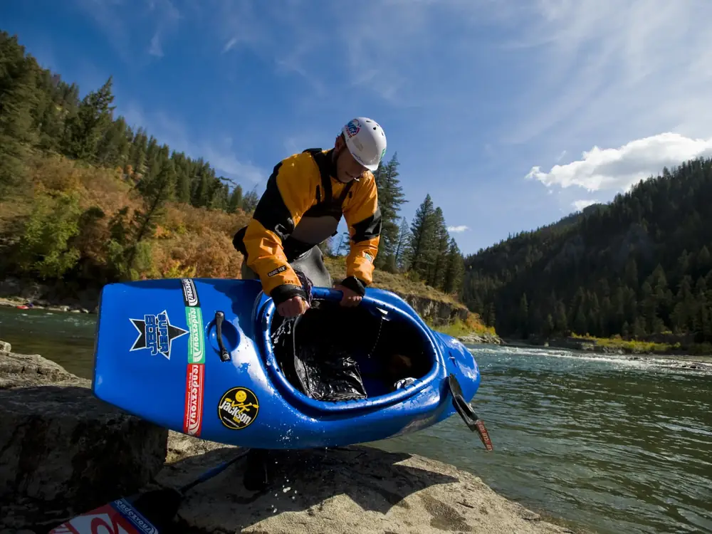 Person in yellow kayak and whitewater river with rapids in Jackson Hole.
