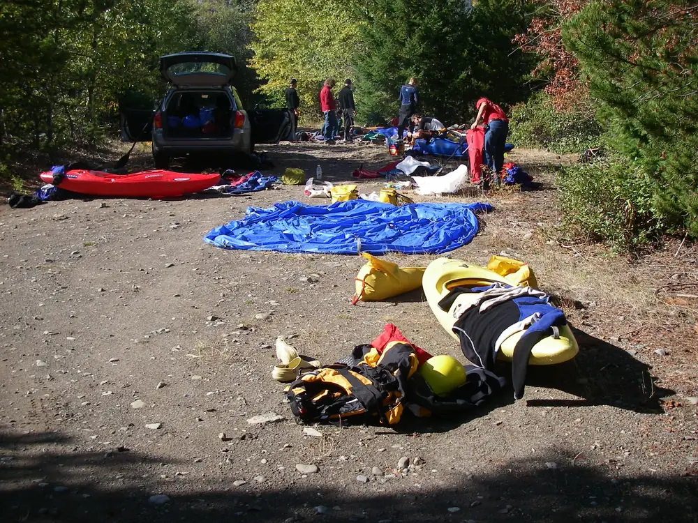 Gravel or dirt clearing with scattered rocks and Dense green trees and shrubs on both sides in Jackson Hole.