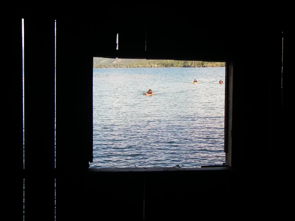 Dark interior framing a rectangular opening and vertical wooden slats on the left side in Jackson Hole.