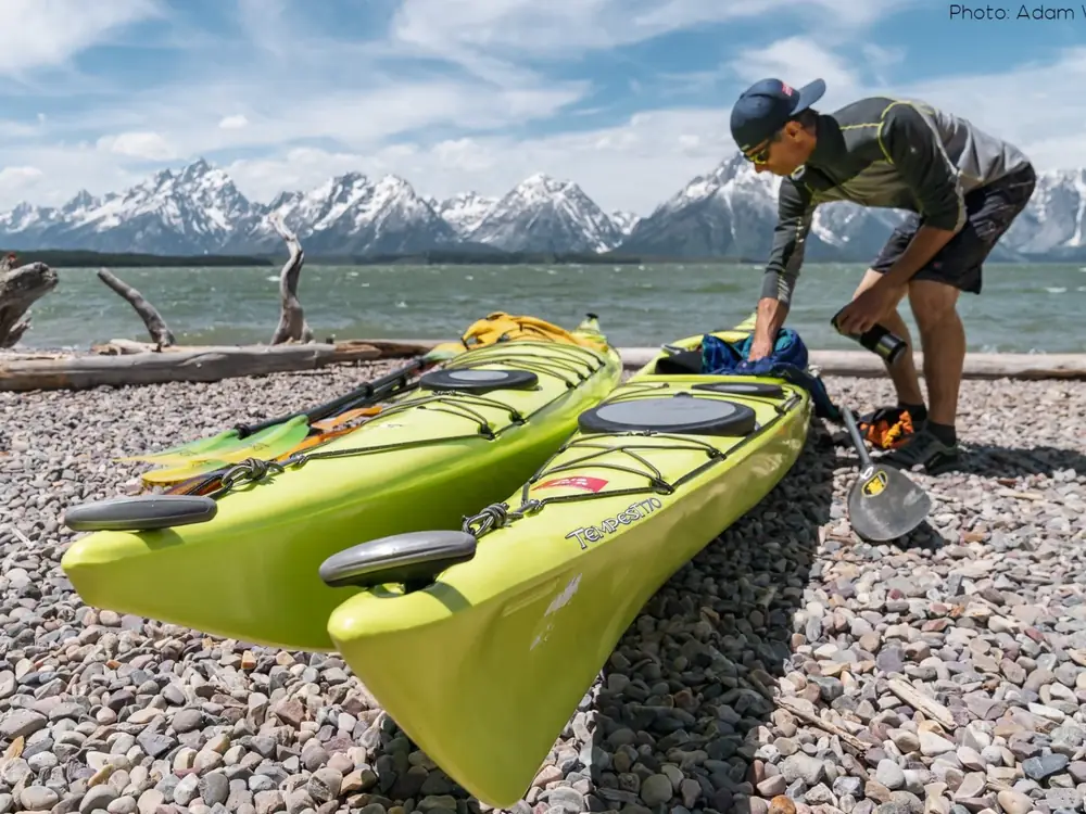 Person in yellow kayak and person in red or orange kayak in Jackson Hole.