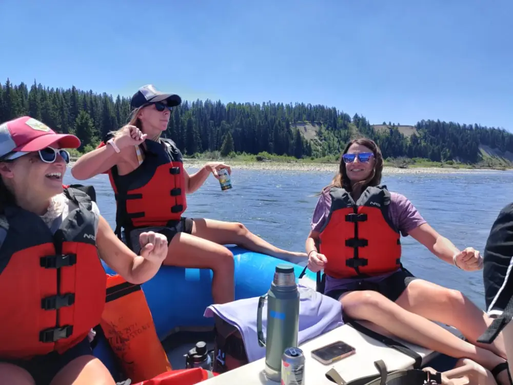 Person in red kayak and rapids with white water in Snake River.