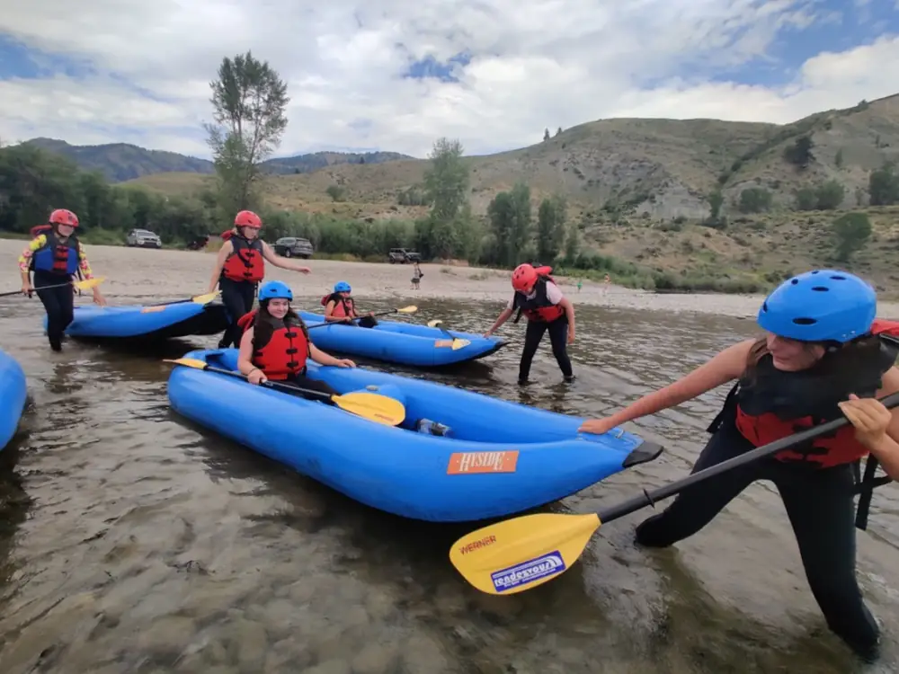 Person in red kayak and whitewater rapids in Snake River.