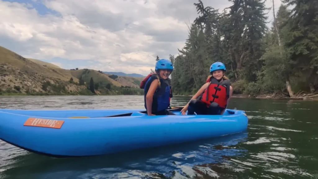 Person in blue kayak and white water rapids in Snake River.