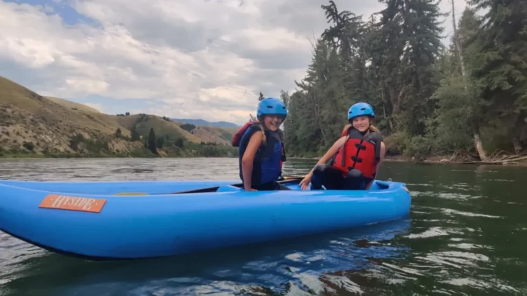 Person in blue kayak and white water rapids in Snake River.