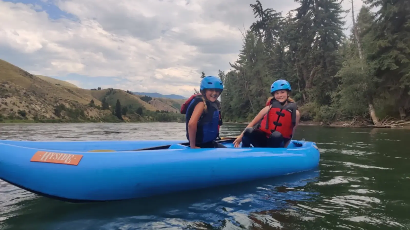Person in blue kayak and white water rapids in Snake River.
