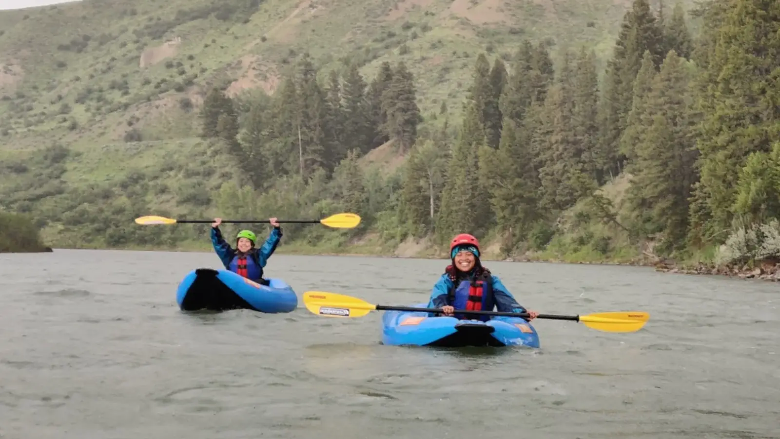 Person in yellow kayak and person paddling in Snake River.