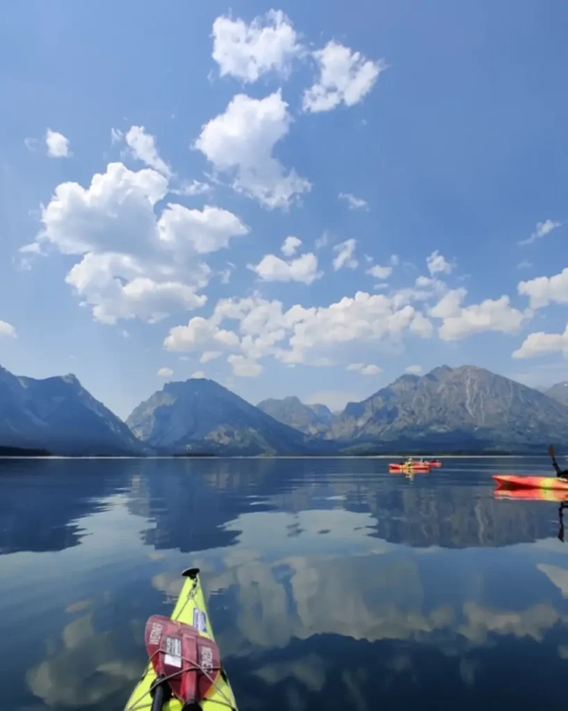Person in yellow kayak and person in blue kayak in Snake River.