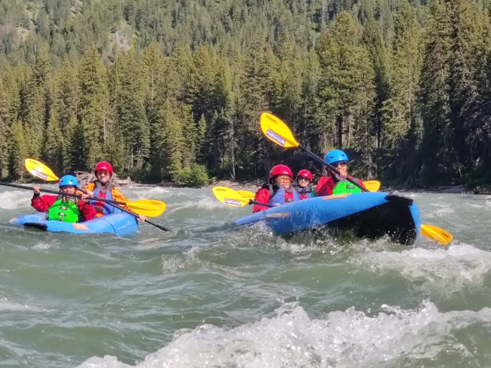 Person in yellow kayak and person in blue kayak in Snake River.