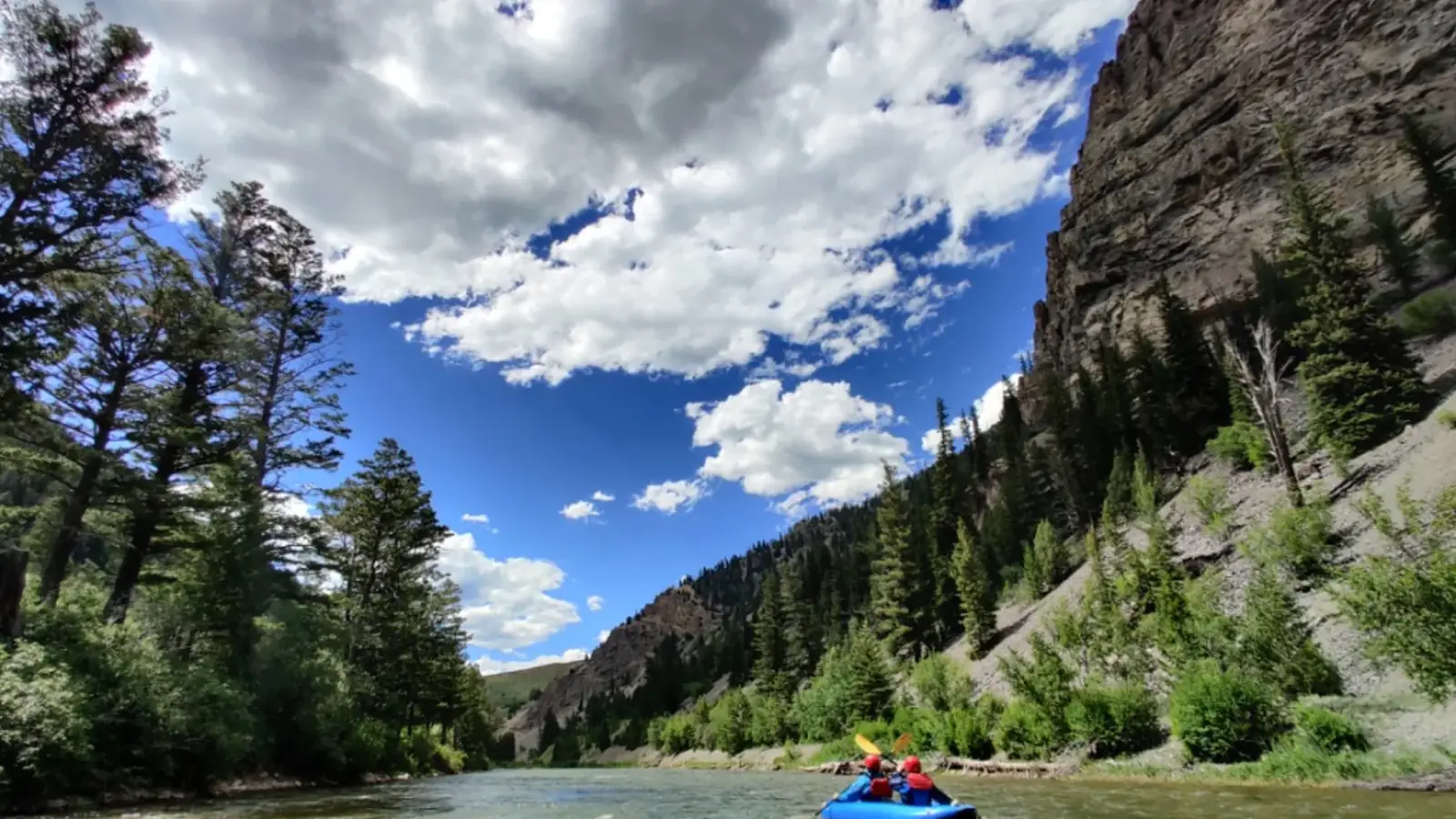 Person in yellow kayak and river with white water rapids in Jackson Hole.