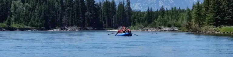 Person in red kayak and whitewater rapids in Snake River.