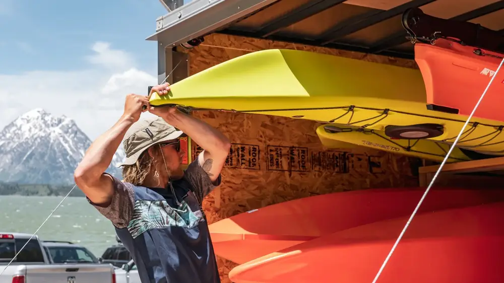 Vintage trailer or camper and person bending over near trailer door in Yellowstone National Park.