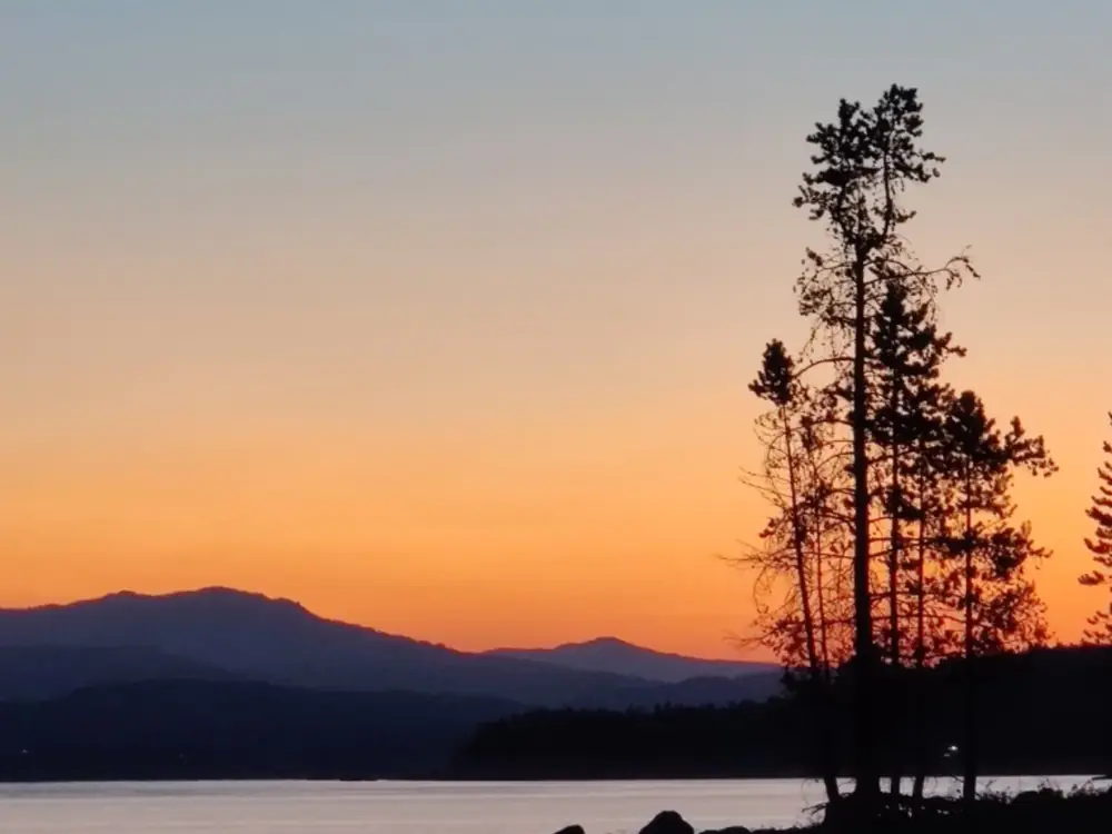 Two people in kayaks and river with rapids and white water in Yellowstone National Park.