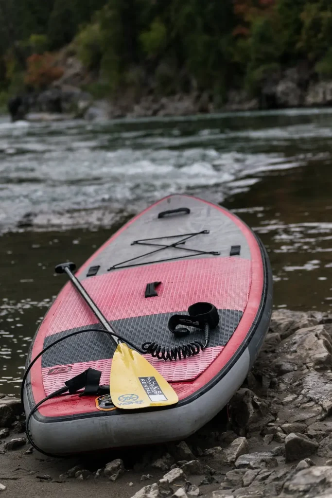 One person standing on a blue board and yellow paddle in the person’s hands in Jackson Hole.