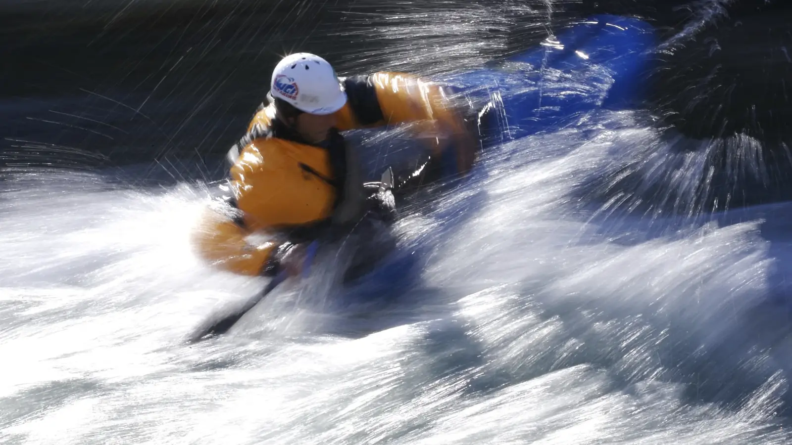 Person in yellow kayak and river with white water rapids in Jackson Hole.