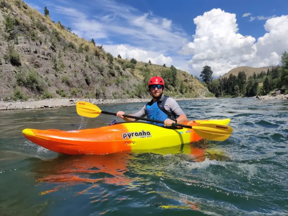 Person in yellow kayak and churning white water rapids in Jackson Hole.