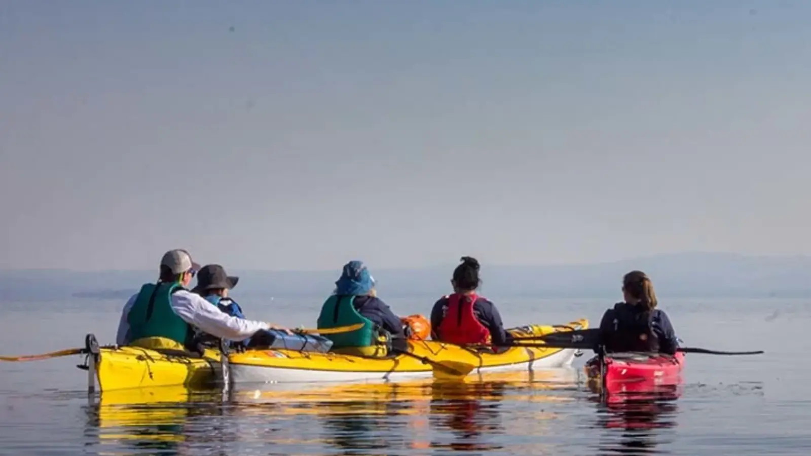 Person in yellow kayak and rushing river water with whitewater rapids in Yellowstone National Park.