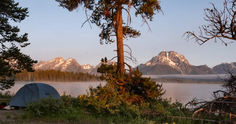 Sunrise alpenglow over the Teton Range from Spalding Bay campsite on Jackson Lake.